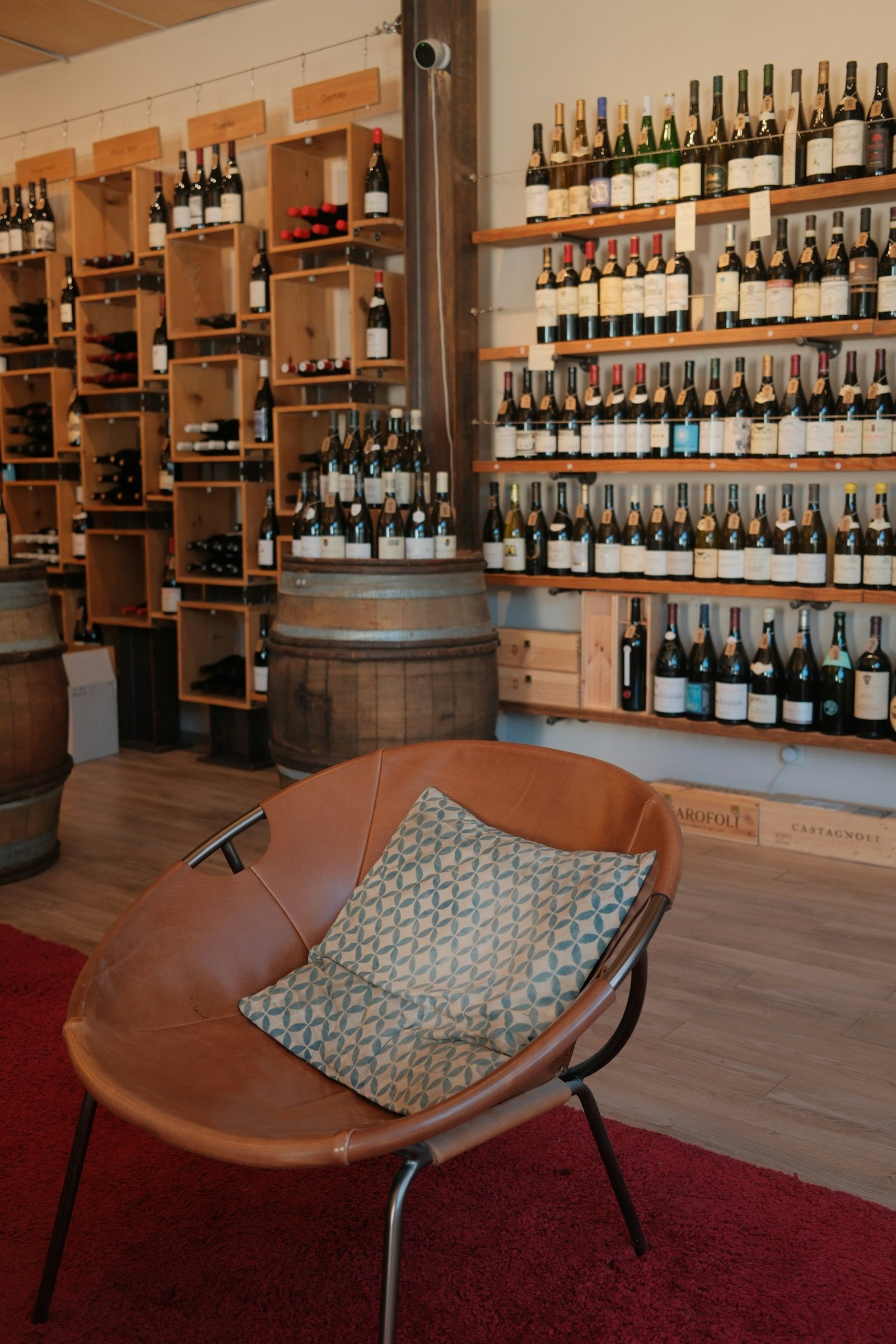 Inside the Cellier shop: wooden shelves of wine bottles and an oak barrel